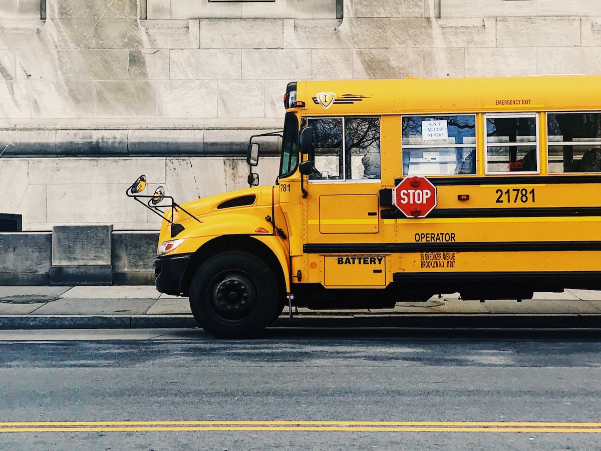 autobus scolaire arrêté devant un bâtiment