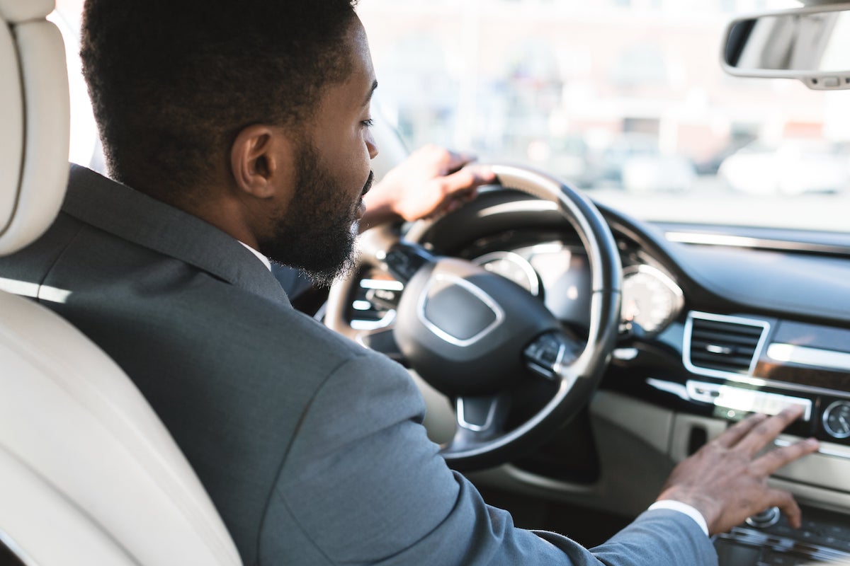 hommes d'affaires qui conduit son auto et qui touche la console