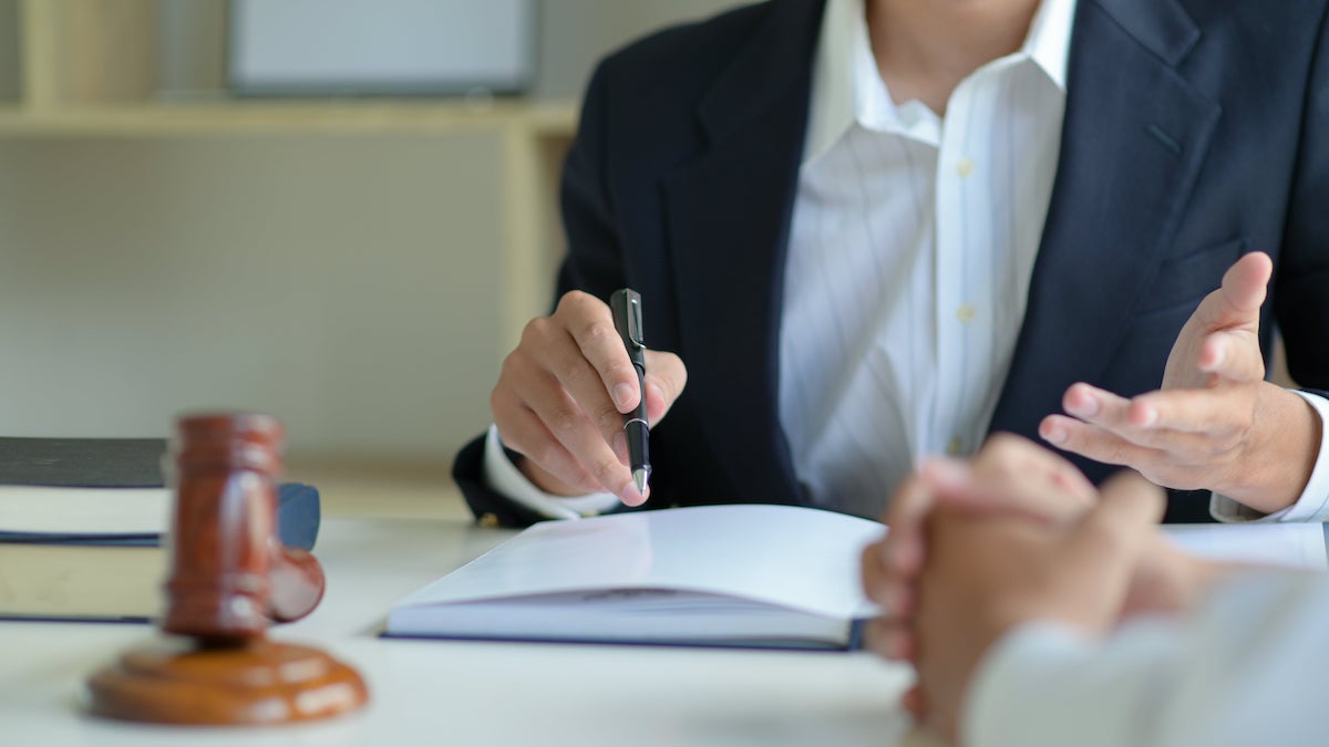 avocat qui prend des notes dans un livre avec un client